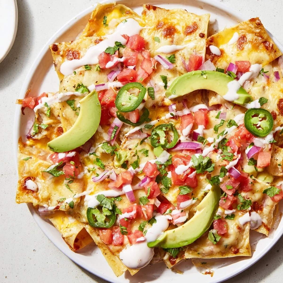 A close-up shot of pasta chips nachos with a creamy, vibrant zesty sauce drizzled on top.