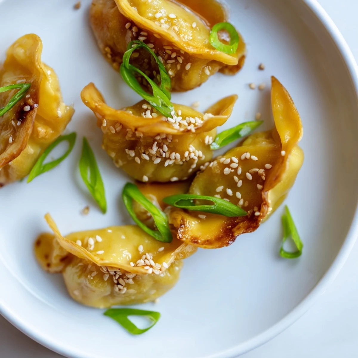 Crispy Air Fryer Frozen Dumplings, infused with savory sesame glaze, garnished with fresh green onions.