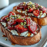 Creamy ricotta toast with strawberries, honey, and pistachios, a perfect quick breakfast.