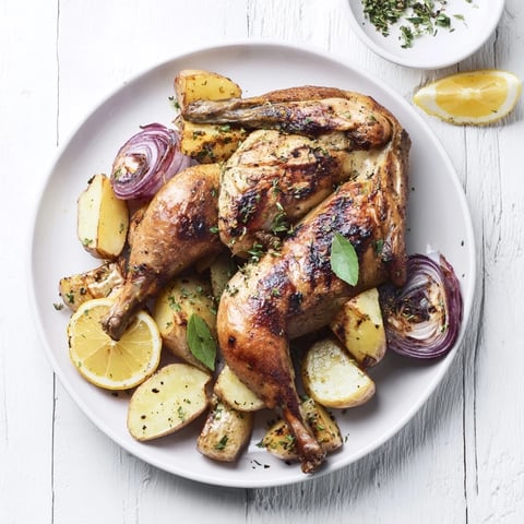 Golden-brown One-Dish Baked Chicken Thighs with Lemon and thyme featuring tender potatoes, perfect for dinner.