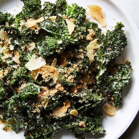 Fresh massaged kale tossed in creamy garlic Parmesan dressing, topped with golden toasted breadcrumbs and shaved Parmesan for a flavorful vegetarian salad.  