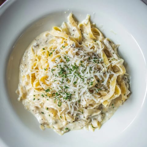 Gleaming strands of The Perfect 20-Minute Creamy Alfredo Pasta, coated in a luscious, savory sauce.