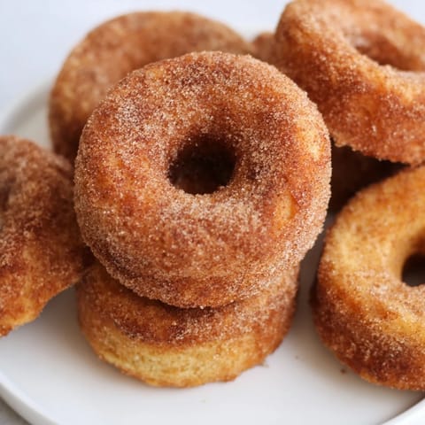 Fluffy 1-Minute Air Fryer Donuts, just pulled from the air fryer, tossed in warm cinnamon sugar coating.