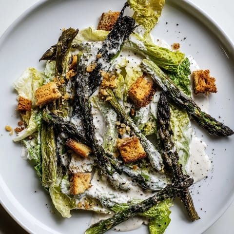 Tender, charred asparagus meets cool romaine and tangy yogurt dressing in this fresh Roasted Asparagus Caesar Salad.  