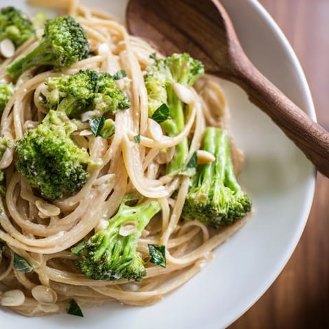 A rustic bowl of One-Pot Lemon Broccoli Pasta topped with Parmesan and fresh basil, steaming beside a glass of white wine.  
