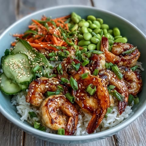 A close-up of a vibrant Asian Shrimp Bowl featuring juicy grilled shrimp, fresh edamame, and colorful carrots.