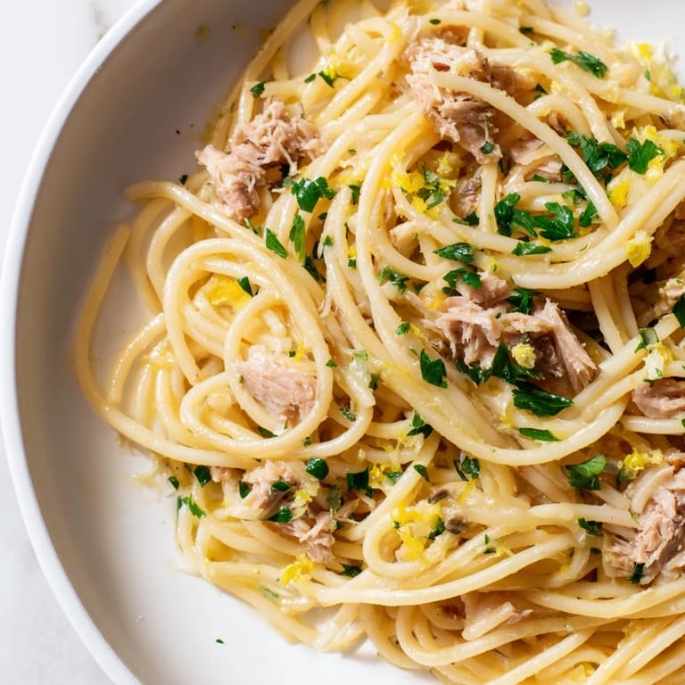 Flaky tuna and zesty lemon mingle in this vibrant Lemon-Garlic Tuna Spaghetti dish, ready in minutes.