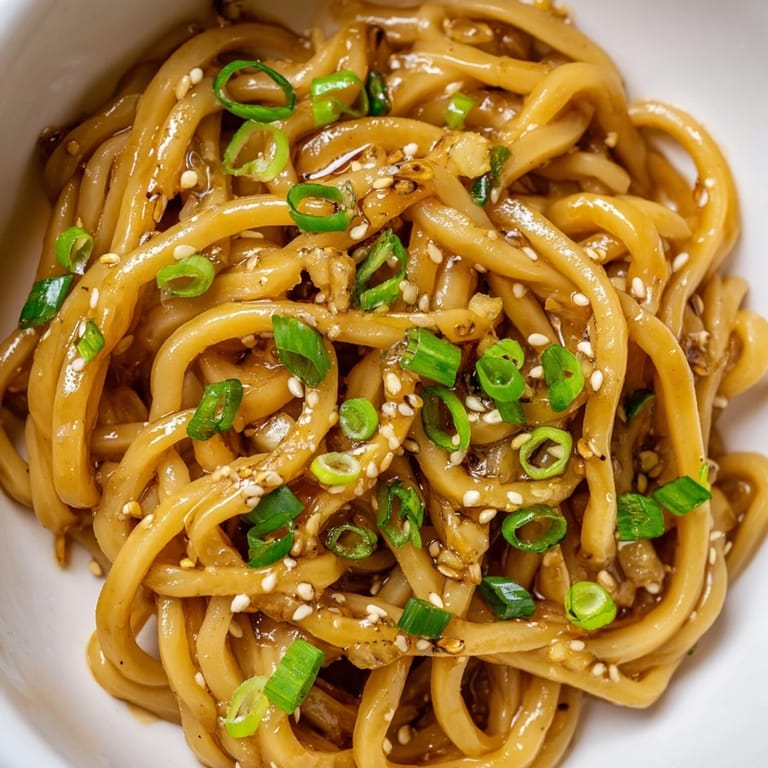 Freshly prepared Asian Garlic Noodle Bowl served in a rustic ceramic bowl with chili slices