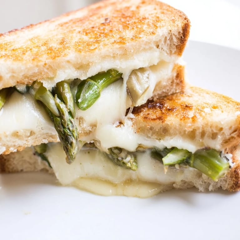 Freshly grilled asparagus and gooey Brie fill buttery bread in a comforting Asparagus & Brie Grilled Cheese.