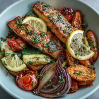 Golden-brown roasted salmon fillets and vibrant, caramelized vegetables fresh from the oven on a sheet pan.